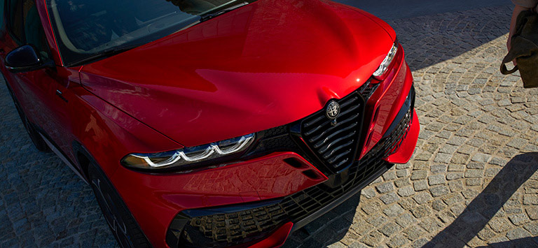 Vista elevada del frente de un Alfa Romeo Tonale Sport Speciale 2026 rojo, con énfasis en la parrilla Scudetto en V.