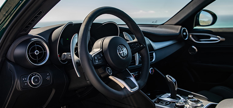 The steering wheel and instrumentation in a 2026 Alfa Romeo Giulia.
