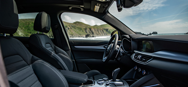 The front seats, steering wheel and Uconnect touchscreen in the 2026 Alfa Romeo Stelvio.